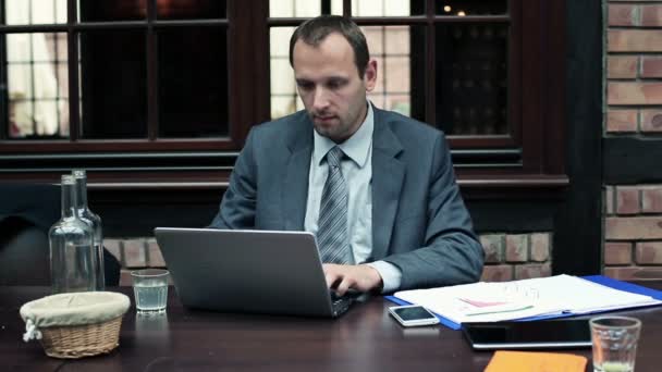 Бизнесмен с ноутбуком и документами — стоковое видео