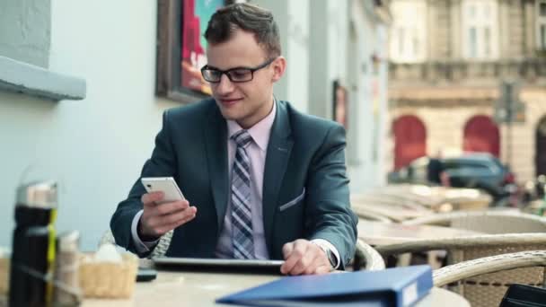 Joven hombre de negocios con tablet y celular — Vídeos de Stock