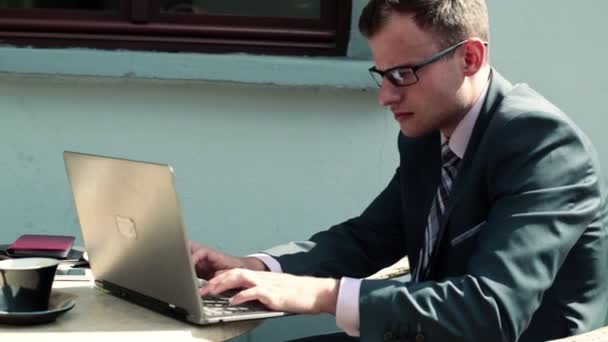 Бизнесмен, работающий за ноутбуком во время обеда — стоковое видео