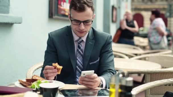 Zakenman met smartphone tijdens de lunch — Stockvideo