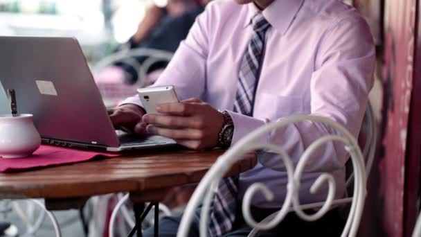 Бизнесмен со смартфоном и ноутбуком — стоковое видео
