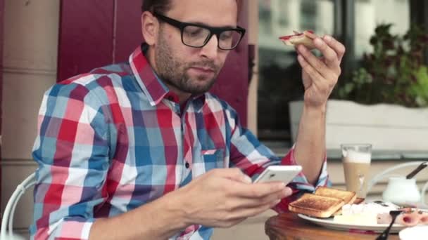 Homme avec smartphone pendant le petit déjeuner — Video