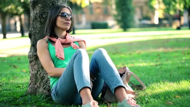 Женщина сидит в парке — стоковое видео