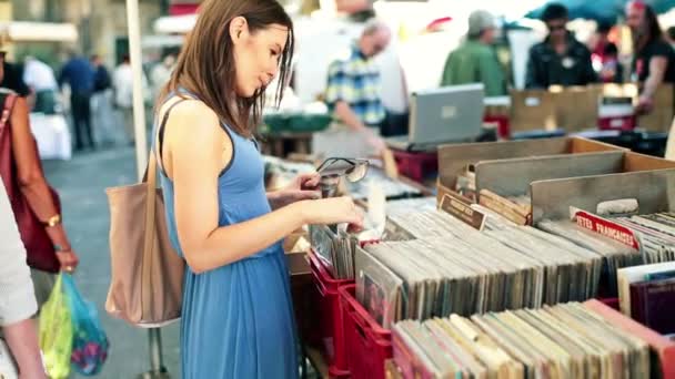 Kvinna som tittar på gamla vinylskivor — Stockvideo