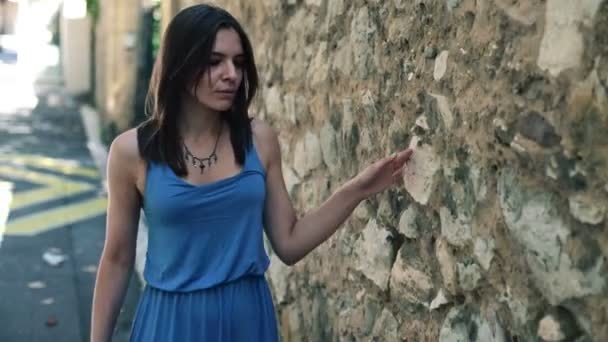 Mujer caminando por la pared de piedra — Vídeos de Stock