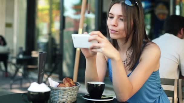 Жінка зі смартфоном в кафе — стокове відео