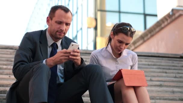 Empresarios que trabajan con teléfonos inteligentes y tabletas — Vídeo de stock