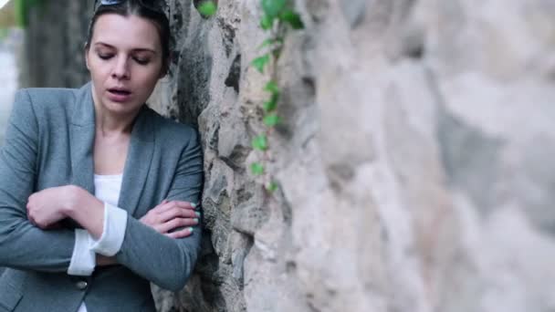 Woman standing by stone wall — Stock Video