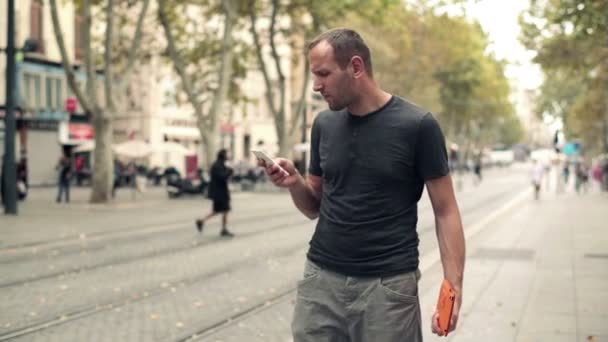 Un uomo che parla al cellulare in città — Video Stock