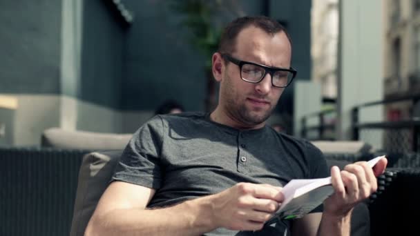 Homme lisant le livre et buvant du café — Video