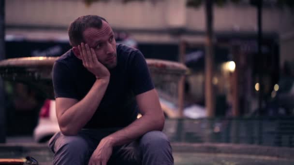 Trauriger Mann, der in der Stadt sitzt — Stockvideo