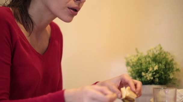 Женщина готовит, ест сэндвич — стоковое видео