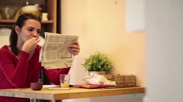 Mujer desayunando y leyendo el periódico — Vídeos de Stock