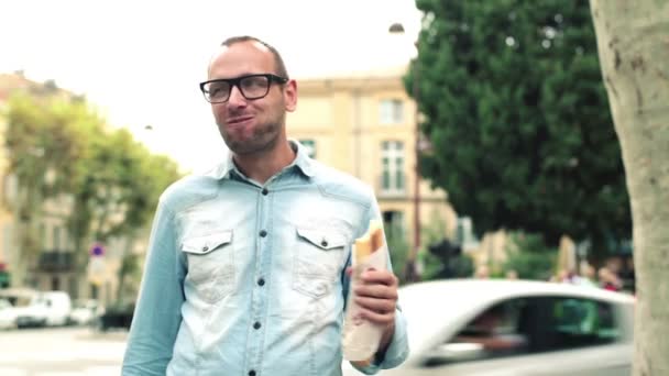 Человек ест багет — стоковое видео