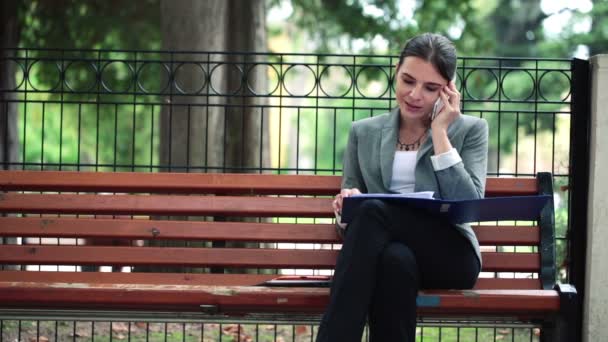Femme d'affaires sur téléphone portable et lecture de documents — Video