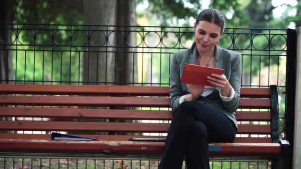 Businesswoman using tablet on bench — Stock Video