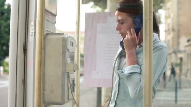 Mujer llamando al teléfono en cabina telefónica — Vídeo de stock