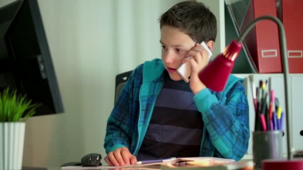 Boy with cellphone and homework — Stock Video