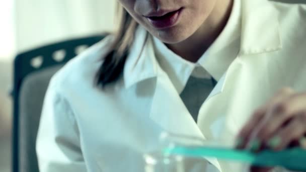 Ученые смешивают химикаты в колбе Эрленмейера — стоковое видео
