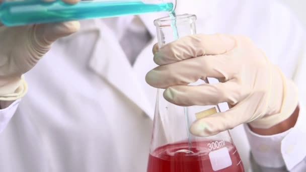 Wissenschaftler gießt Chemikalien in Erlenmeyerkolben, — Stockvideo