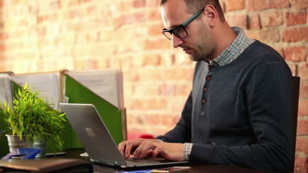 Jongeman werkt aan laptop — Stockvideo