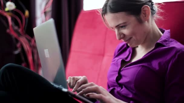 Gelukkige vrouw met laptop op sofa — Stockvideo