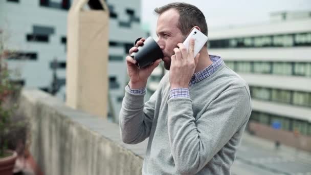 Man praten op mobiele telefoon en het drinken van thee — Stockvideo