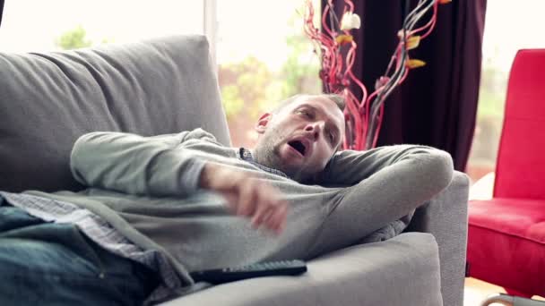 Hombre en el sofá viendo la televisión — Vídeos de Stock