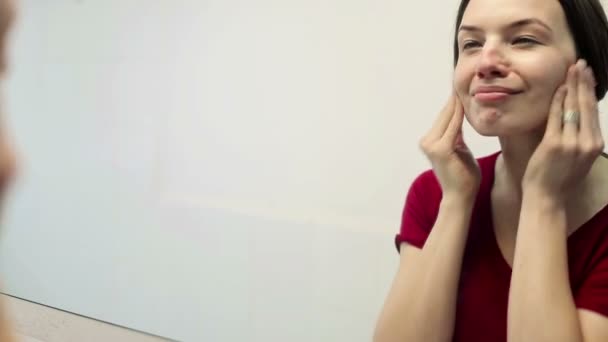 女性の顔にクリームを適用します。 — ストック動画