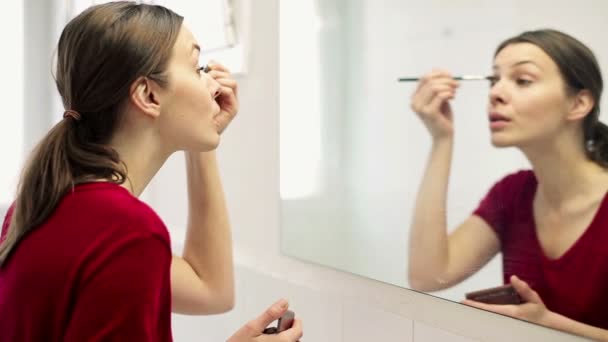 Woman applying makeup on eyelid with brush — Stock Video