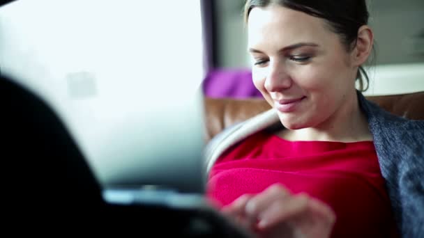 Женщина с ноутбуком на диване дома — стоковое видео
