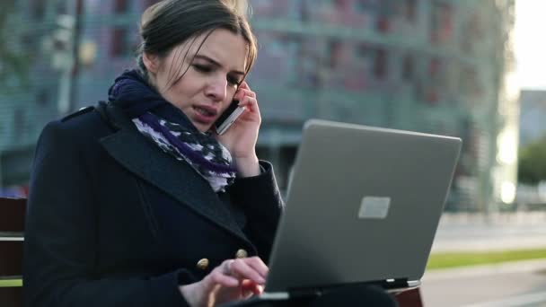 Женщина с мобильным телефоном и ноутбуком — стоковое видео