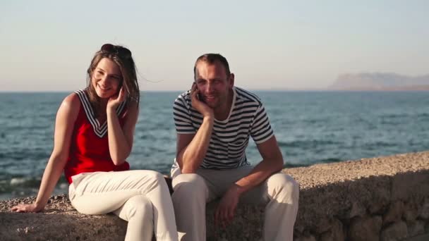 Couple talking on cellphone by sea — Stock Video
