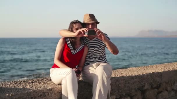 Pareja tomando fotos junto al mar — Vídeo de stock