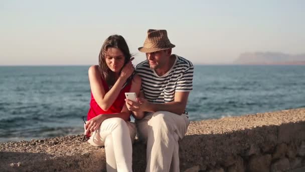 Pareja con smartphone por mar — Vídeo de stock