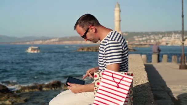 Deniz yoluyla online alışveriş yapan erkek — Stok video