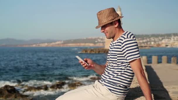 Homme heureux envoyant des SMS par la mer — Video