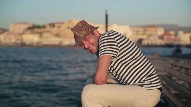 Hombre alegre sentado junto al mar — Vídeos de Stock