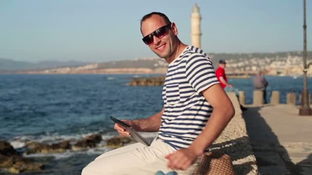 Man met tablet pc door zee — Stockvideo