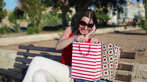 Kobieta rozmowy na telefon komórkowy i sprawdzanie torby — Wideo stockowe