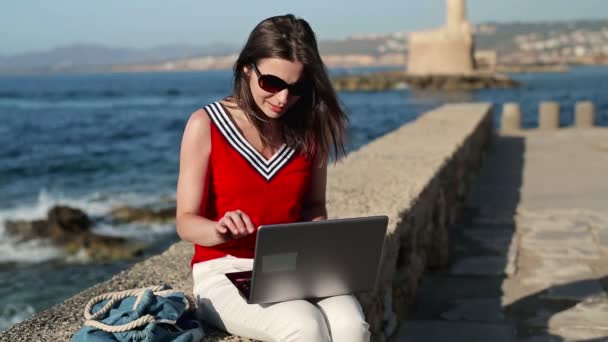 Mujer con portátil relajante por el mar — Vídeos de Stock