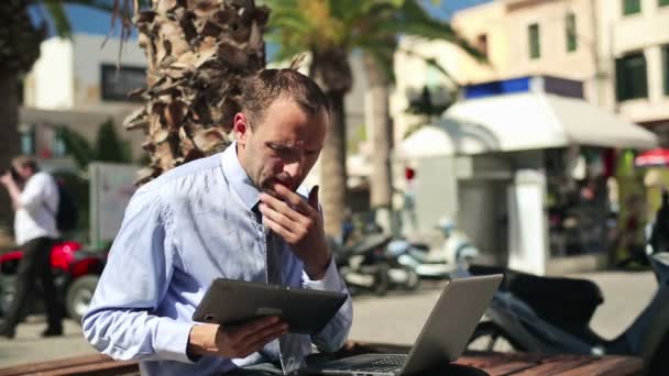 Бизнесмен, работающий на ноутбуке и планшете — стоковое видео