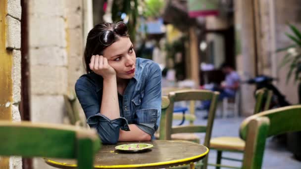 Грустная женщина сидит в кафе — стоковое видео
