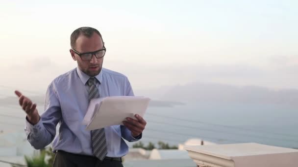 Беспокойный бизнесмен читает документы — стоковое видео