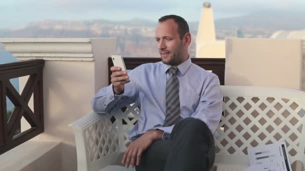 Бизнесмен со смартфоном на террасе — стоковое видео