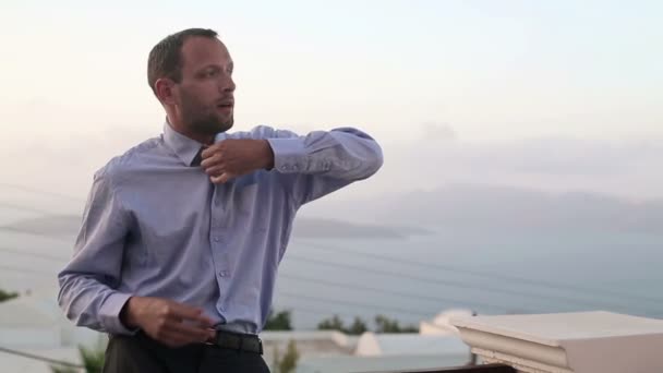Бізнесмен роздягається на терасі — стокове відео