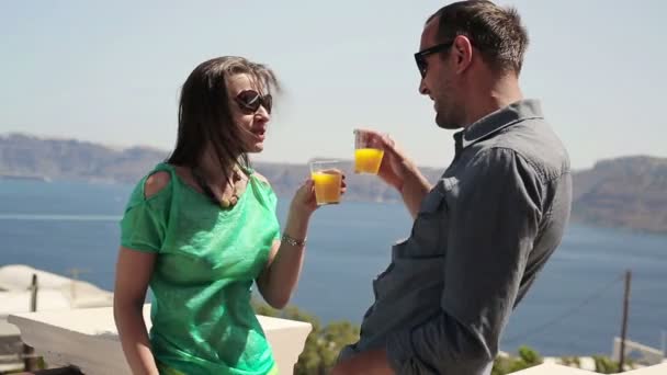Пара поднимающих тост с коктейлем на террасе — стоковое видео