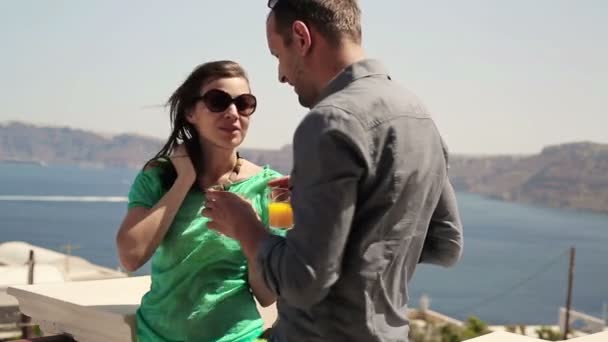 Pareja bebiendo jugo en terraza — Vídeos de Stock