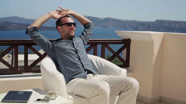 Hombre feliz estirándose en la terraza — Vídeos de Stock