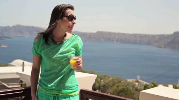 Mujer bebiendo jugo en terraza — Vídeos de Stock